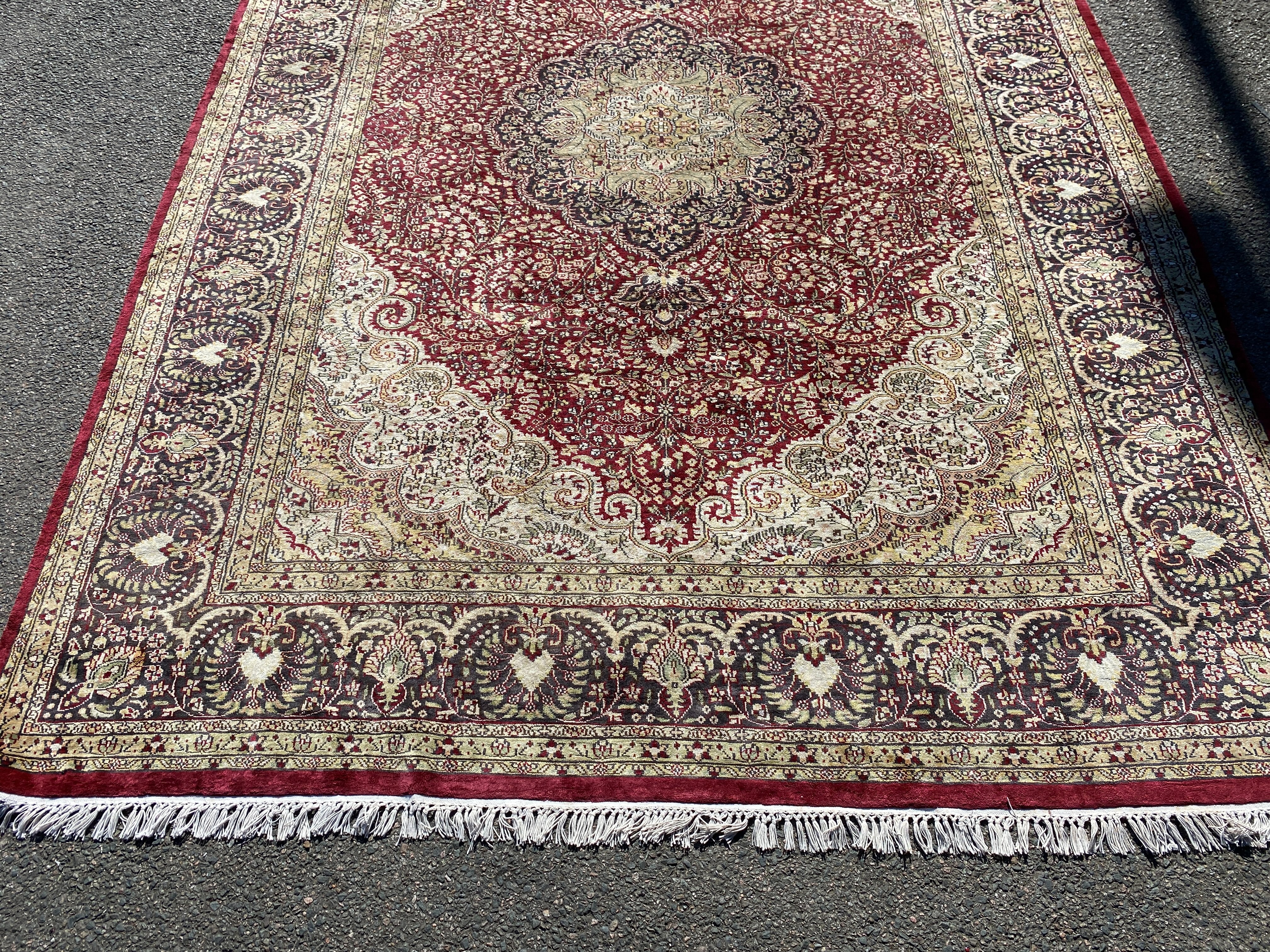 A Kashmiri part silk burgundy ground floral carpet, 330 x 240cm
